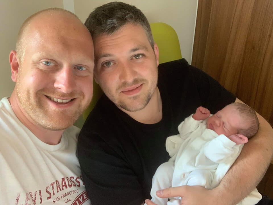 Scott Stephenson, left, and partner Michael Smith, right, with their newborn daughter, Harper, who was born via Scott's sister, Chapelle Cooper, via surrogacy. 