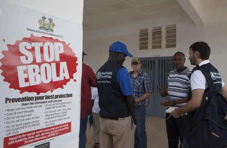 WHO members and health directors stand outside the Port Loko District Hospital September 27, 2014, where the maternity ward has been converted into an isolation holding centre for people with suspected cases of the Ebola virus. REUTERS/Christopher Black/WHO/Handout via Reuters