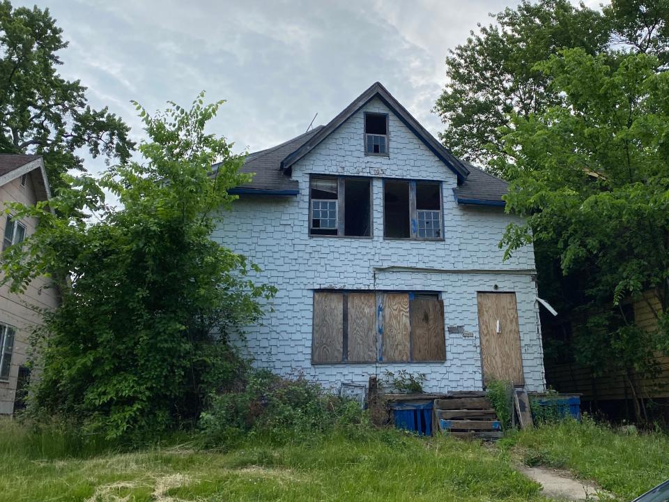 An abandoned home in Detroit with boarded up windows and doors.