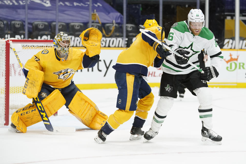 Nashville Predators goaltender Juuse Saros (74) reaches for a shot as Predators defenseman Ryan Ellis (4) and Dallas Stars center Joe Pavelski (16) duck out of the way in the first period of an NHL hockey game Sunday, April 11, 2021, in Nashville, Tenn. (AP Photo/Mark Humphrey)