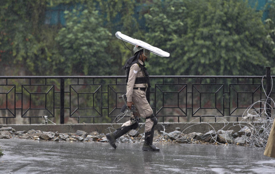 <p>An Indian paramilitary soldier uses his shield to protect him from rain during a curfew in Srinagar, Indian controlled Kashmir, July 27, 2016. (Photo: Mukhtar Khan/AP)</p>