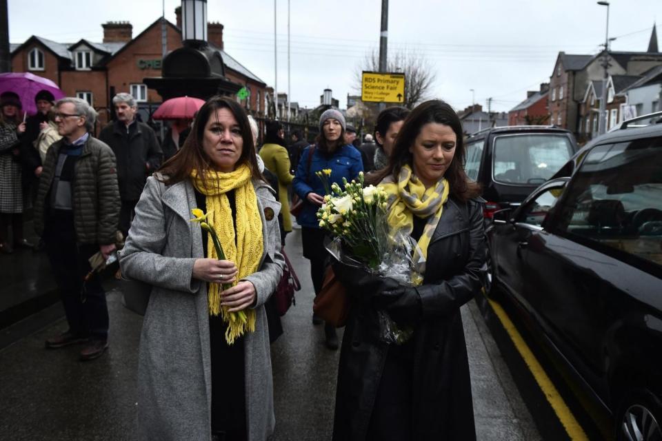 Former school classmates of Dolores O'Riordan carry yellow flowers to signify sunshine (Getty Images)