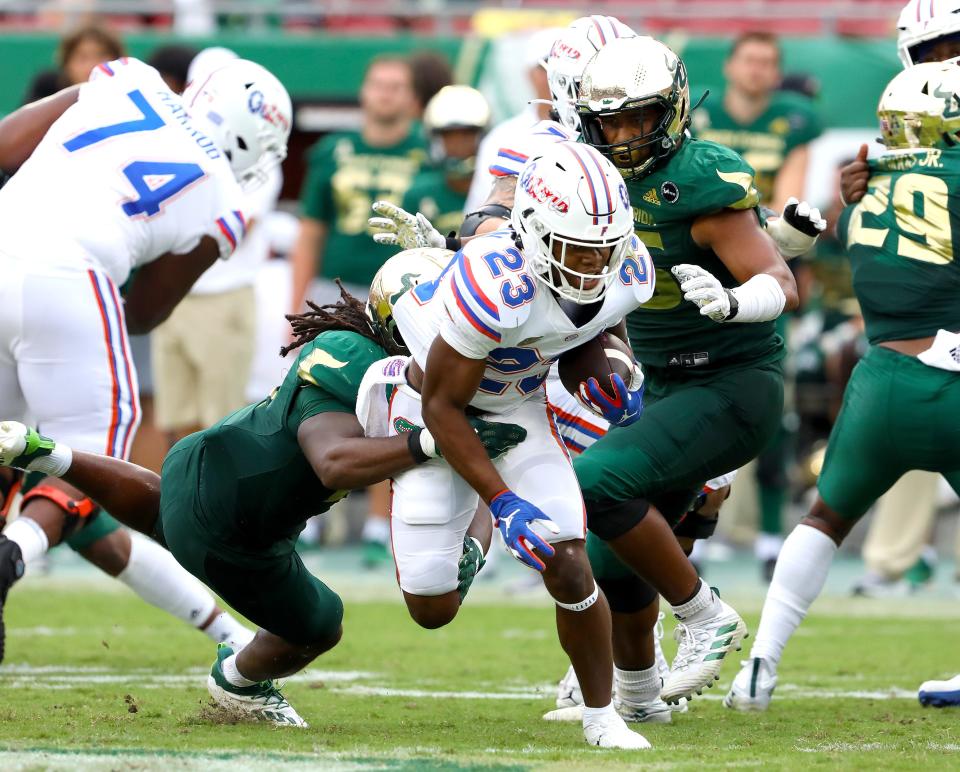 Florida Gators running back Demarkcus Bowman (23) runs through a couple of defenders during the second game of the season against the USF Bulls at Raymond James Stadium, in Tampa Fla. Sept. 11, 2021.