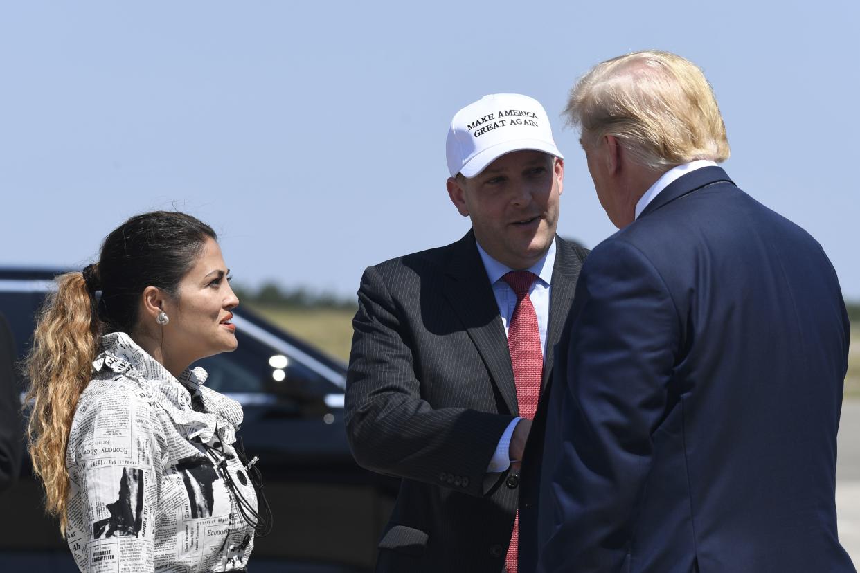 Then-President Donald Trump, right, greets Rep. Lee Zeldin, R-N.Y., center, and his wife Diana Zeldin, left, after arriving at Francis S. Gabreski Airport in Westhampton Beach, N.Y., Friday, Aug. 9, 2019. 