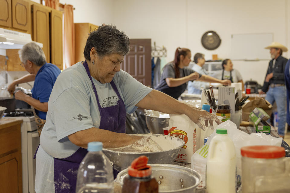 Carol Tiger, a member of Muscogee Nation and an elder at the Springfield United Methodist Church in Okemah, Okla.,, mixes dough to make frybread at the church's annual wild onion dinner on April 5, 2024. Frybread is a staple dish at wild onion dinners, which are common among tribal nations from the southeastern U.S. (AP Photo/Brittany Bendabout)