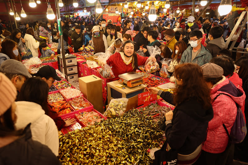 小年夜　迪化街年貨大街買氣旺（1） 農曆春節連假在8日小年夜登場，台北市迪化街年貨 大街販售各式餅乾糖果的店家買氣相當旺，店員忙著 替顧客秤重結帳。 中央社記者王騰毅攝　113年2月8日 