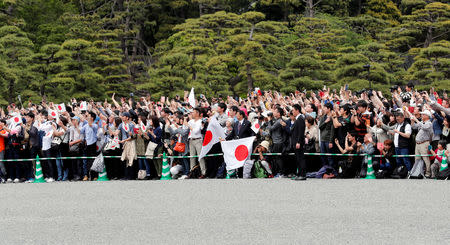 People wave Japanese flags and take pictures of Emperor Naruhito as he leaves the Imperial Palace in Tokyo, Japan May 1, 2019. REUTERS/Kim Kyung-Hoon