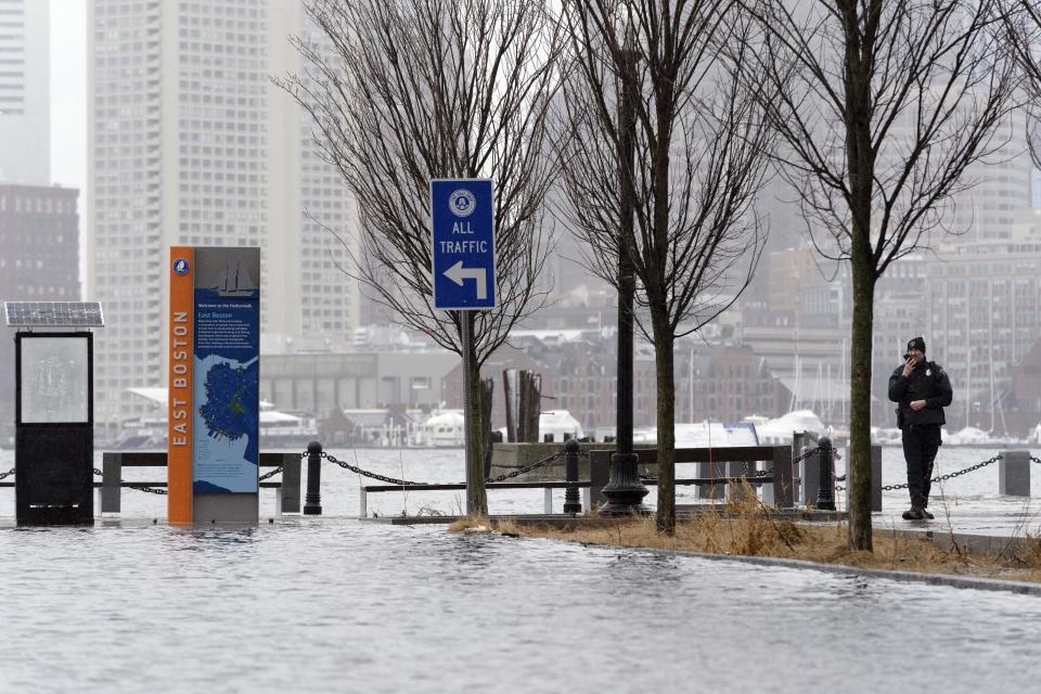 Water floods the street at East Pier during high tide, Tuesday, Feb. 13, 2024, in the East Boston neighborhood of Boston. (AP Photo/Michael Dwyer)