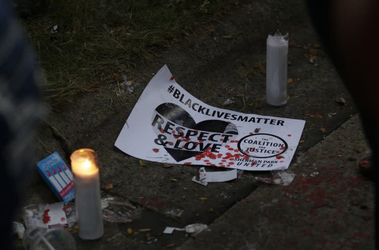 A sign and candles were left at the location where Sylville Smith was shot and killed by a Milwaukee police officer. (Photo: Jeffrey Phelps/AP)