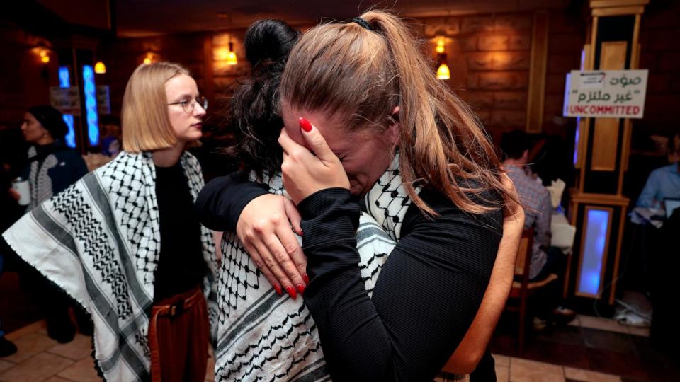 PHOTO: People hug at the Listen to Michigan watch party, a group who asked voters to vote uncommitted instead of for President Joe Biden in Michigan's primary election, in Dearborn, Mi., Feb. 27, 2024.  (Jeff Kowalsky/AFP via Getty Images)