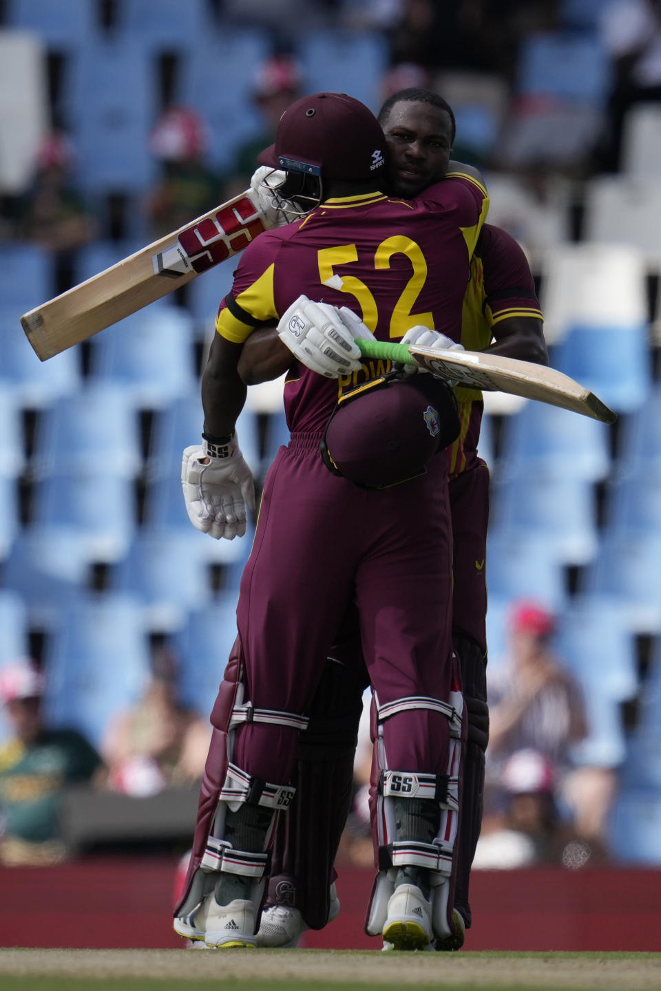 West Indies's batsman Johnson Charles, back, embraces teammate Rovman Powell after reaching his century during the second T20 cricket match between South Africa and West Indies, at Centurion Park, in Pretoria, South Africa, Sunday, March 26, 2023. (AP Photo/Themba Hadebe)