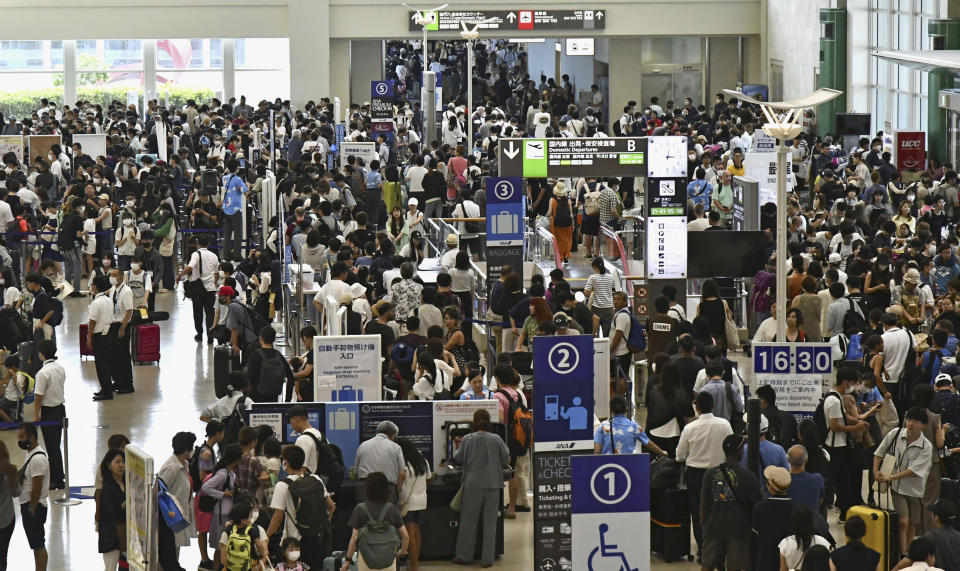 The airport floor is filled with people waiting due to flight cancellations, in Naha, Okinawa, southern Japan, Thursday, Aug. 3, 2023. The typhoon that damaged homes and knocked out power on Okinawa and other Japanese islands this week was slowly moving west Thursday but is forecast to make a U-turn and dump even more rain on the archipelago. (Kyodo News via AP)