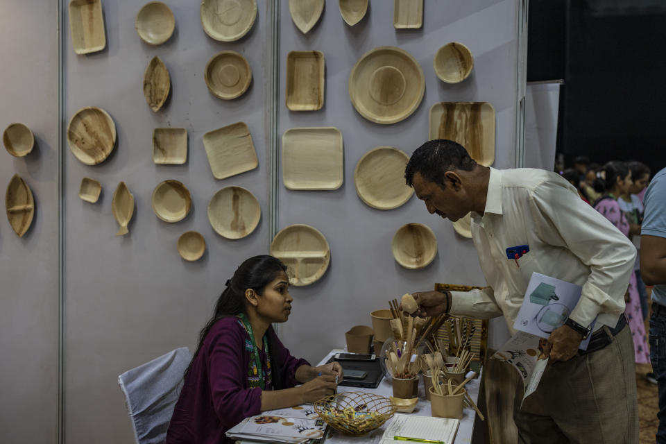 A visitor makes enquiries about eco-friendly cutlery items at an event to create awareness about eco-friendly products in New Delhi, India, Friday, July 1, 2022. India banned some single-use or disposable plastic products Friday as part of a federal plan to phase out the ubiquitous material in the nation of nearly 1.4 billion people. (AP Photo/Altaf Qadri)