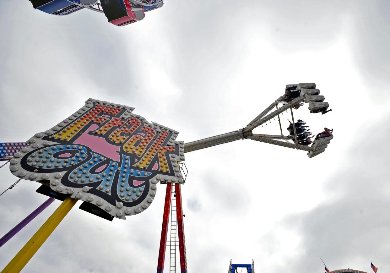 Riders fly over the midway on the Freak Out during the Whaling City Festival at Buttonwood Park in New Bedford.