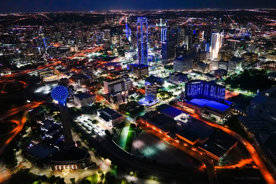 In an aerial vies, buildings in the Dallas skyline are illuminated in blue Thursday, April 9, 2020. Cities and buildings across the nation were lighted in blue to show support for those fighting COVID-19. (Smiley N. Pool/The Dallas Morning News via AP) ORG XMIT: TXDAM321