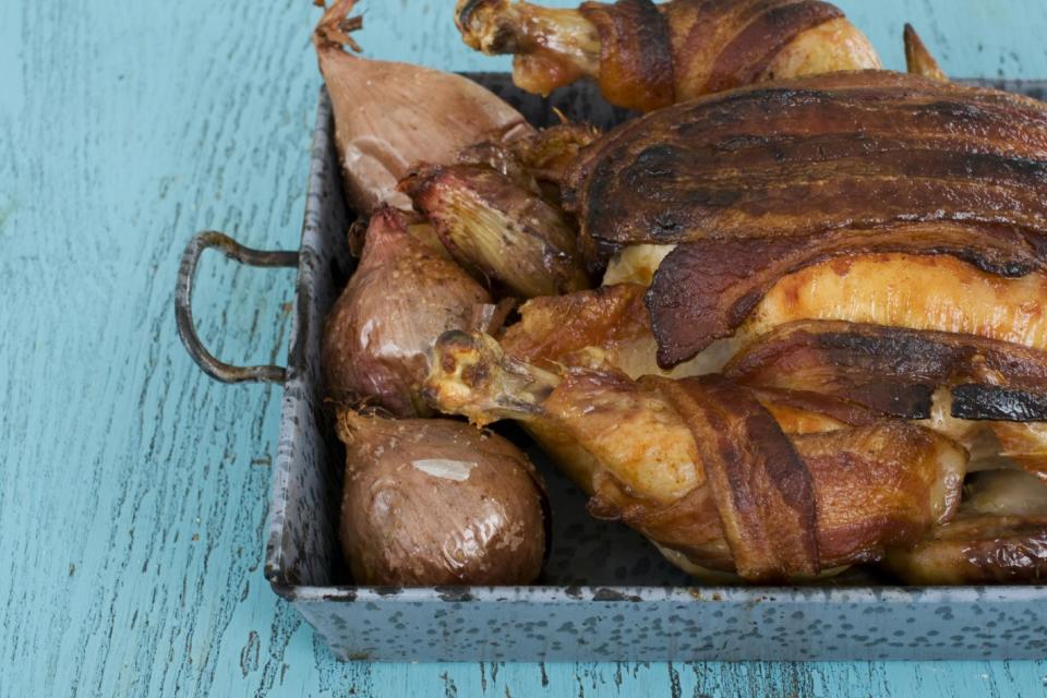 In this image taken on February 11, 2013, roasted chicken with 40 cloves of garlic and a bacon blanket is shown in Concord, N.H. (AP Photo/Matthew Mead)