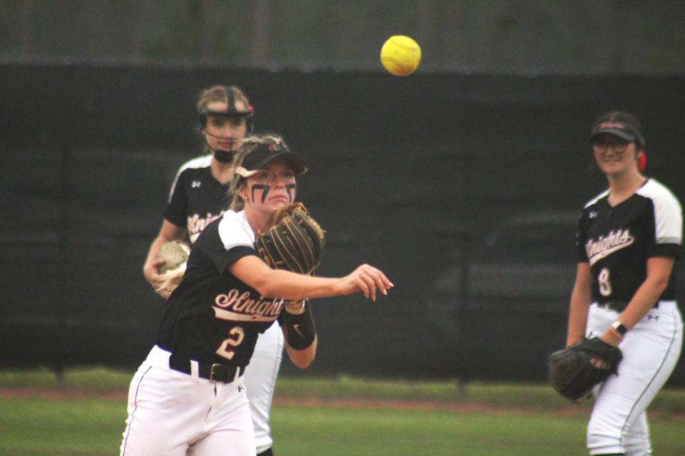Creekside's Bella Campbell (2) makes a throw to first base before Thursday's softball playoff against Timber Creek.
