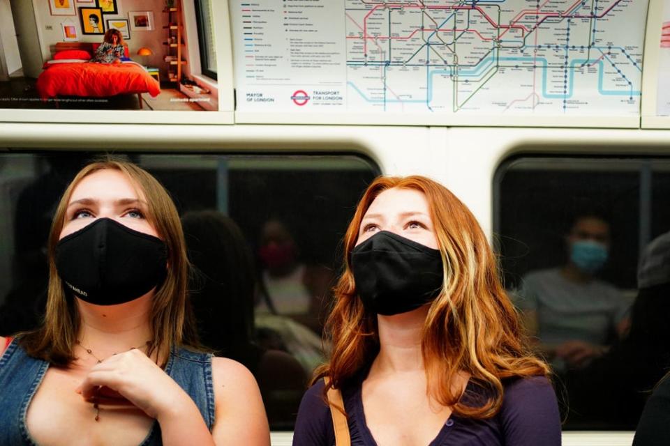 Two women wearing facemasks on a Tube train (Victoria Jones/PA) (PA Wire)