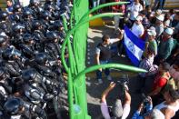 National guard look at migrants, part of a caravan travelling to the U.S., as they wait to cross in to Mexico at the border between Guatemala and Mexico, in Ciudad Hidalgo