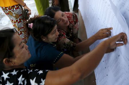 Women look at names on a list outside a polling station ahead of tomorrow's general election in Mandalay, Myanmar, November 7, 2015. REUTERS/Olivia Harris