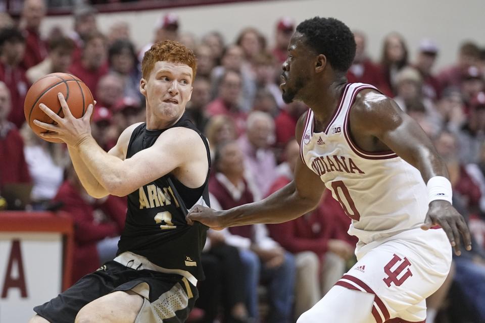 Army's Ryan Curry, left, is defended by Indiana's Xavier Johnson (0) during the first half of an NCAA college basketball game, Sunday, Nov. 12, 2023, in Bloomington, Ind. (AP Photo/Darron Cummings)