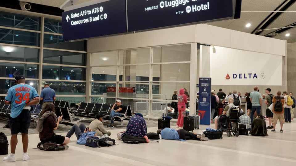 Travelers wait in a long line to speak with a Delta representative at the help desk in the McNamara terminal at the Detroit Metropolitan Wayne County Airport on July 20. - Joe Raedle/Getty Images