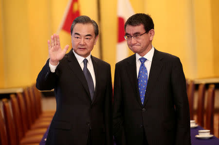 Chinese State Councilor and Foreign Minister Wang Yi (L) and Japan's Foreign Minister Taro Kono gesture at their meeting in Tokyo, Japan April 15, 2018. Behrouz Mehri/Pool via Reuters