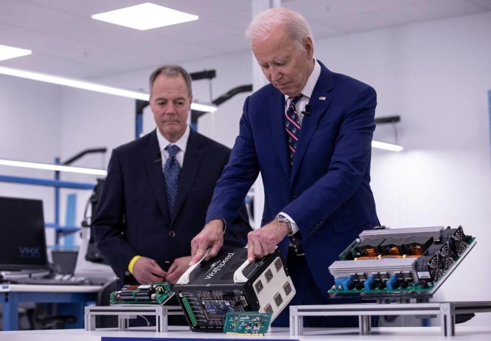 President Joe Biden stands with Wolfspeed CEO Gregg Lowe while touring a power applications lab at Wolfspeed on Tuesday, March 28, 2023, in Durham, N.C.
