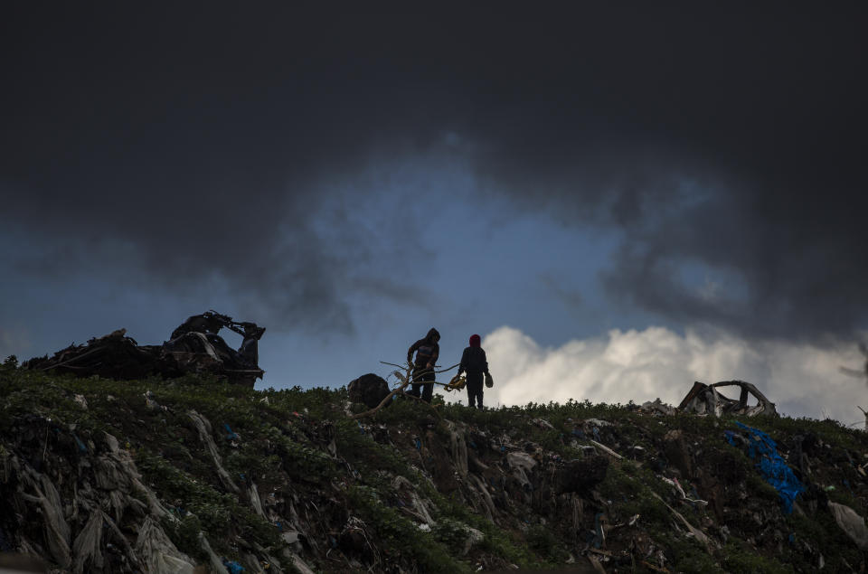 Two Palestinian boys play on top of piles of garbage on a rainy day in a poor neighbourhood of Khan Younis, in the southern Gaza Strip, Wednesday, Jan. 20, 2021. (AP Photo/Khalil Hamra)