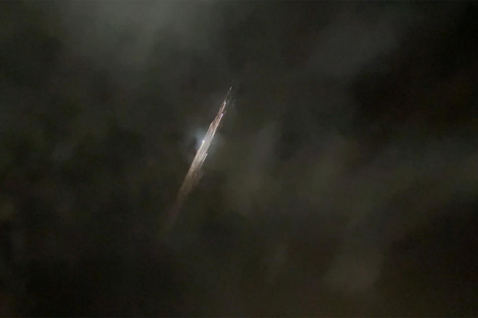 In this image taken from video provided by Roman Puzhlyakov, debris from a SpaceX rocket lights up the sky behind clouds over Vancouver, Wash. Thursday evening, March 25, 2021. The remnants of the second stage of the Falcon 9 rocket left comet-like trails as they burned up upon re-entry in the Earth's atmosphere according to a tweet from the National Weather Service. (Roman Puzhlyakov via AP)