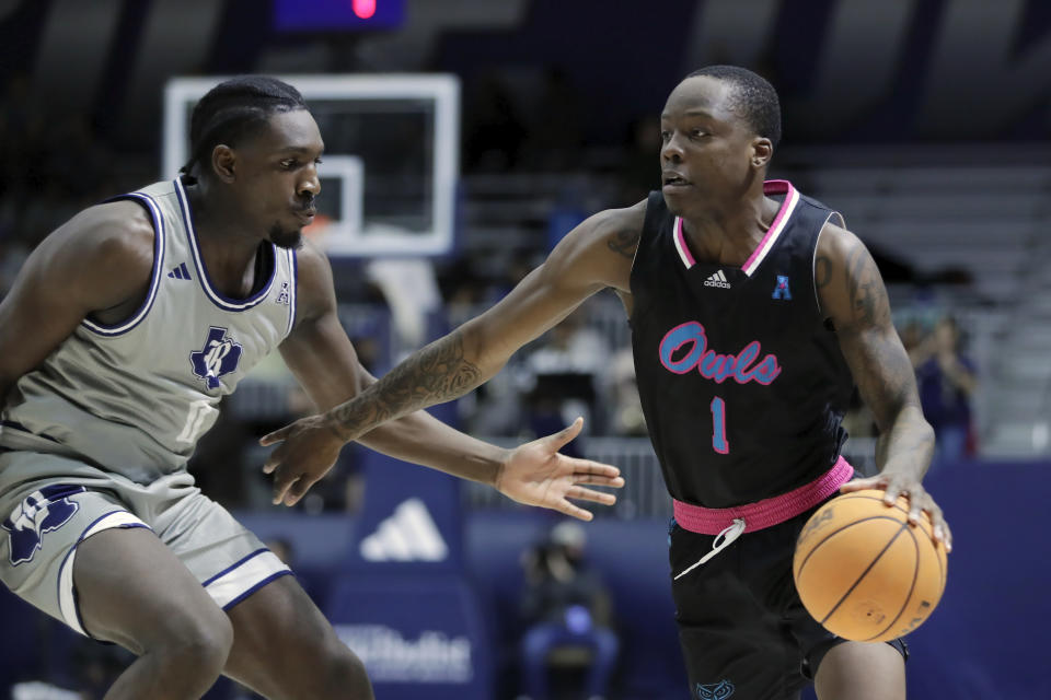 Florida Atlantic guard Johnell Davis (1) drives around Rice forward Sam Alajiki, left, during the first half of an NCAA college basketball game Wednesday, Jan. 24, 2024, in Houston. (AP Photo/Michael Wyke)