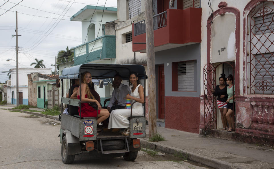 Brides Lisset Diaz Vallejo, left, and Liusba Grajales travel in a taxi to the notary office to get married in Santa Clara, Cuba, Friday, Oct. 21, 2022. The couple, who have been together for seven years, is one of the first to make the decision to get legally married in Cuba following the new Family Code, which opened up everything from equal marriage to surrogate mothers. (AP Photo/Ismael Francisco)