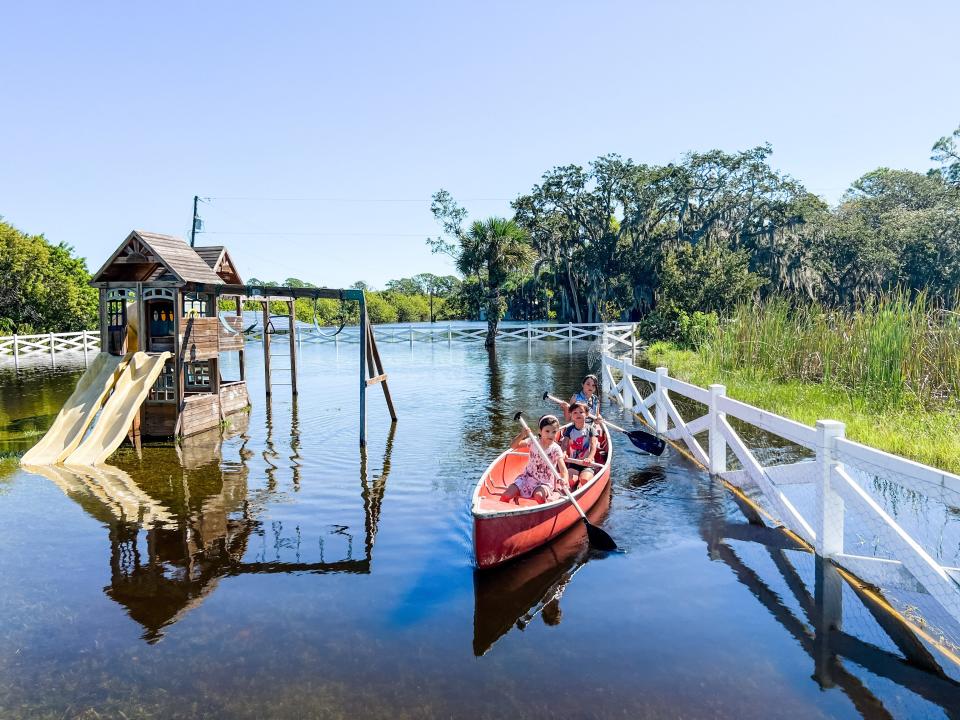 Carlia Alderman's three children go kayaking in their flooded, north Merritt Island yard.