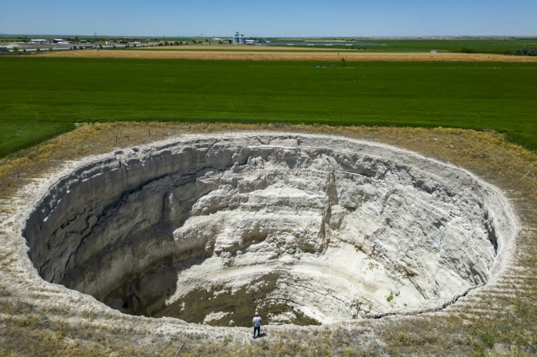 Farmer Yigit Aksel stares into a sinkhole in fields near Karapinar in central Turkey (Yasin AKGUL)