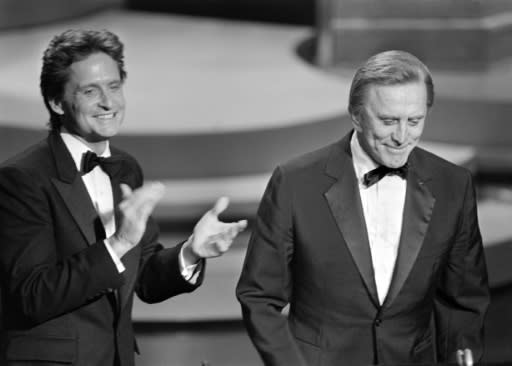Michael Douglas (L) applauds his father Kirk Douglas during the 57th Annual Academy Awards, in Hollywood in March 1985