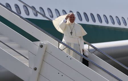 Pope Francis waves as he boards his plane to leave for his pastoral visit to South Korea, August 13, 2014. REUTERS/Alessandro Bianchi