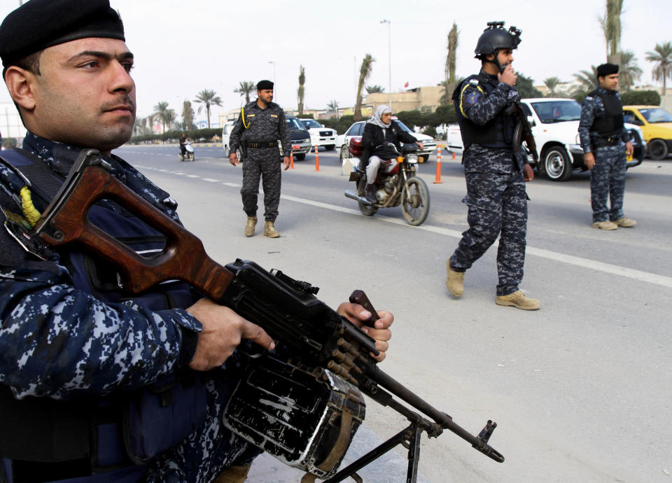 Iraqi federal policemen stand guard at a checkpoint in Basra, Iraq's second-largest city, 340 miles (550 kilometers) southeast of Baghdad, Iraq, Thursday, Jan. 2, 2014. The Iraqi government has tightened its security measures after security forces have arrested, Wathiq al-Batat, a controversial Shiite cleric who leads an Iranian-backed militia called Mukhtar Army. (AP Photo/Nabil al-Jurani)