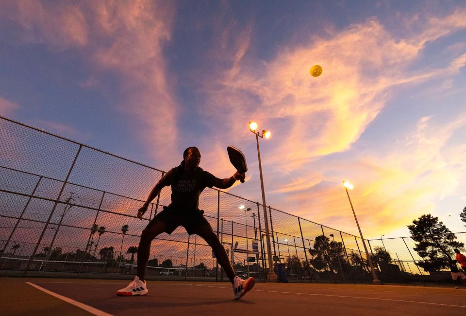 Jamara Saah plays a game of pickleball at sunset in 111-degree heat at Roadrunner Park. Phoenix experienced the 20th day in a row of temperatures of 110 degrees or more, a new record.