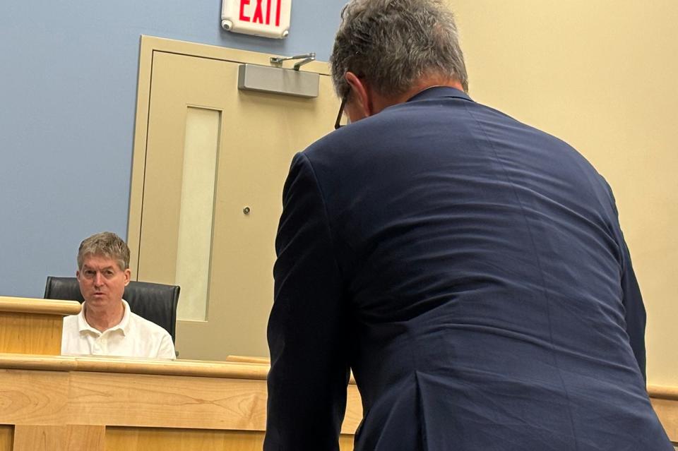Paul Sorli, co-owner of the Portsmouth Gas Light Co., testifies at a New Hampshire Liquor Commission hearing in Concord on Wednesday, Nov. 15, 2023. His business' attorney, Jon Flagg, is seen standing with his back turned.