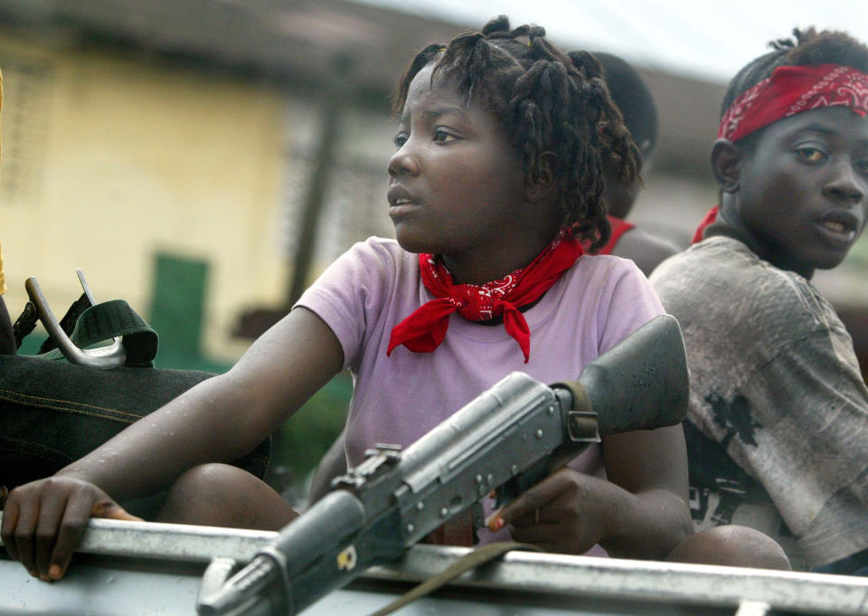 <p>A young female soldier sits in a truck just prior to a rebel attack July 19, 2003 near front line positions just outside Monrovia, Liberia. In an unexpected move, rebels attacked the capital this afternoon. (Photo by Chris Hondros/Getty Images) </p>