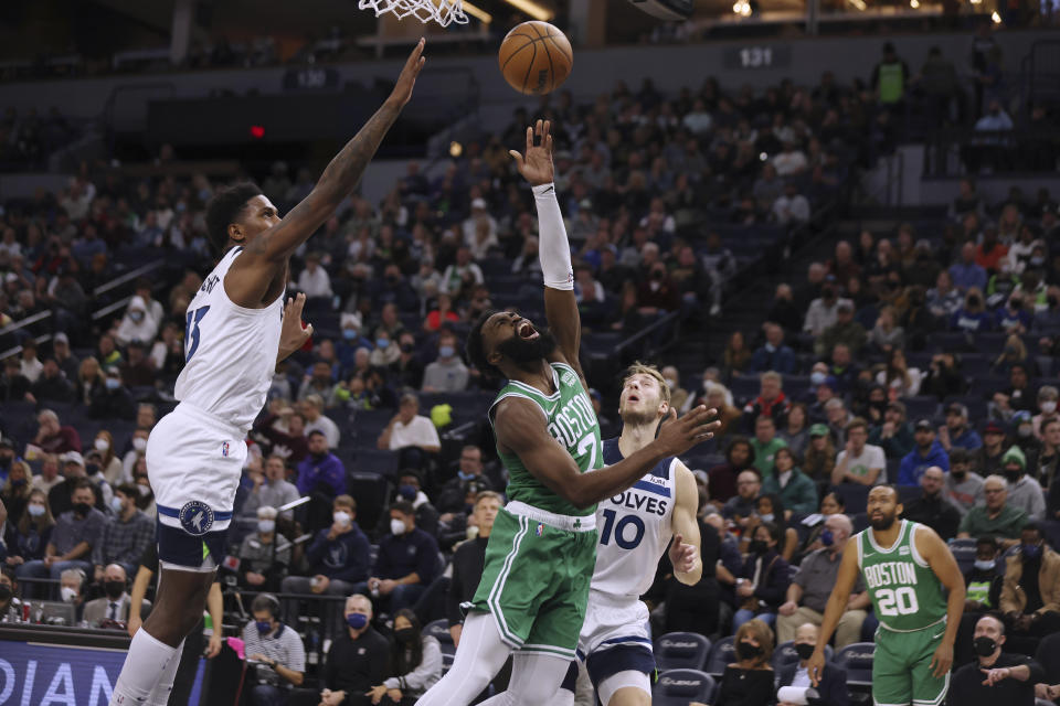 Boston Celtics guard Jaylen Brown (7) shoots as Minnesota Timberwolves forward Nathan Knight (13) defends during the first half of an NBA basketball game Monday, Dec. 27, 2021, in Minneapolis. (AP Photo/Stacy Bengs)