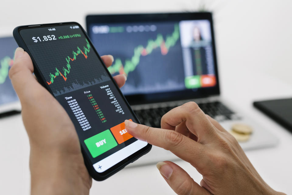 Female manager selling cryptocurrencies through mobile phone app. Stock market, investment and cryptocurrencies concept