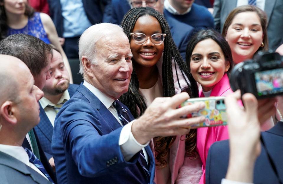 Joe Biden takes a selfie with students at Ulster University (Reuters)