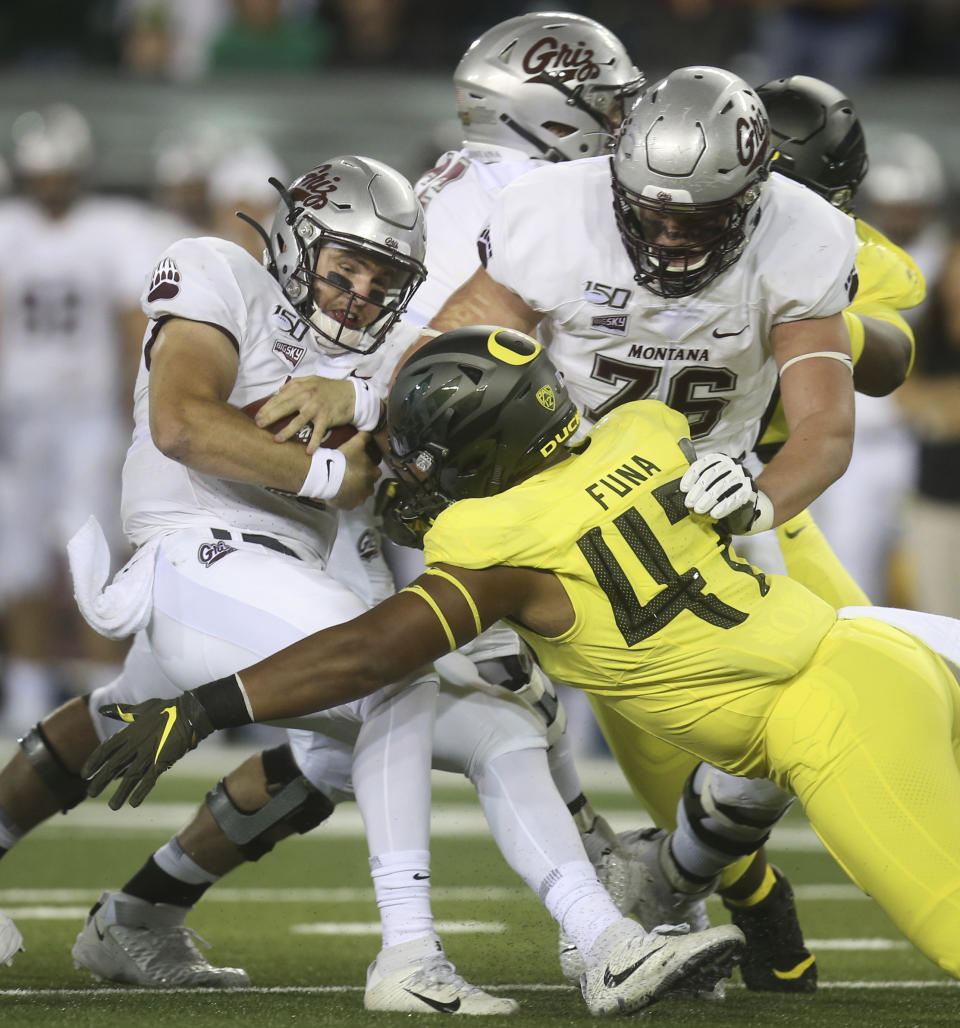 Montana quarterback Dalton Sneed, left, is sacked by Oregon's Mase Funa (No.47) off a block by Montana's Colton Keintz, right, during the first quarter of an NCAA college football game Saturday, Sept. 14, 2019, in Eugene, Ore. (AP Photo/Chris Pietsch)