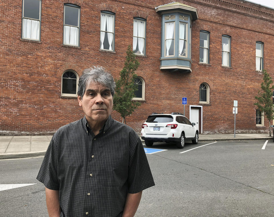 In this Oct. 23, 2018 photo, Delmiro Trevino poses in front of a building in Independence, Ore., where the Hi-Ho restaurant used to be located. It was in that restaurant, in 1977, that Trevino was in when three sheriff's deputies and a policewoman came in and demanded he show documents proving he was American. The racial profiling of Trevino, an American born in Texas, led to Oregon becoming America's first sanctuary state. Now, Oregonians are deciding in the Nov. 6 election whether to repeal the law, even as some other states, like Vermont, have adopted sanctuary policies and others, like Texas, have banned towns from adopting them. (AP Photo/ Andrew Selsky