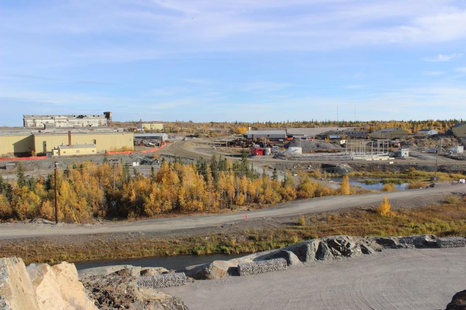 A photo of part of the Giant Mine site, taken from on top of a flat surface where thermosiphon technology is going to be installed. On the right side of the photo, you can see a series of long shapes jutting up from the ground. That's a spot where thermosiphon technology was tested out. 