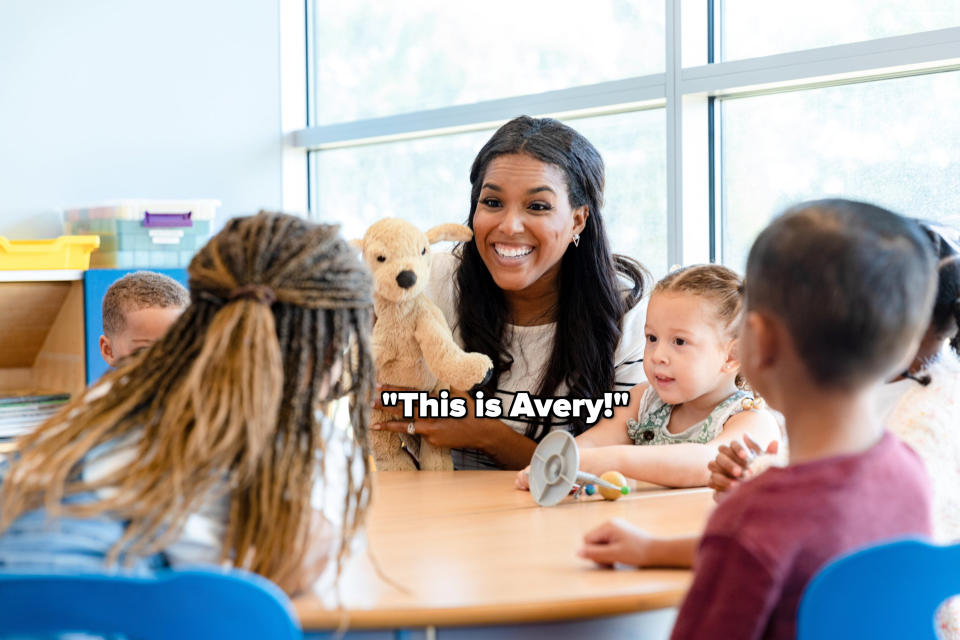 Woman shows children a teddy bear in a classroom setting