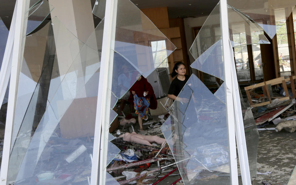 In this Sunday, Sept. 30, 2018, file photo, people survey inside a shopping mall damaged following earthquakes and a tsunami in Palu, Central Sulawesi, Indonesia. (AP Photo/Tatan Syuflana, File)