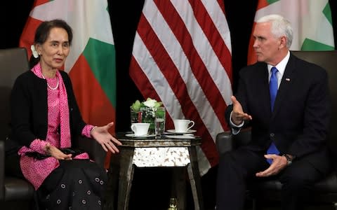 Suu Kyi, seated next to Pence, was stony-faced as he spoke - Credit: ATHIT PERAWONGMETHA/ REUTERS