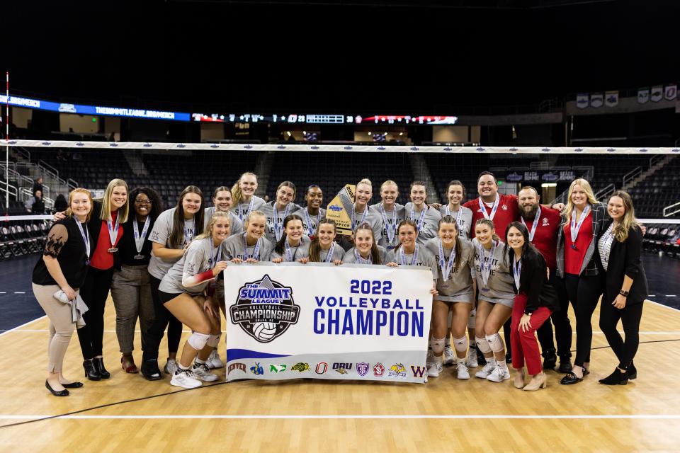 South Dakota Volleyball poses with the Summit League Championship banner after beating Omaha in straight sets on Saturday, Nov. 26, 2022.